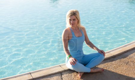 Téléchargez les photos : Belle forme jeune femme travaillant à l'extérieur près de la piscine. - en image libre de droit