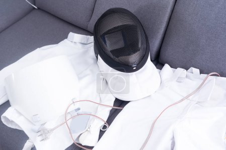 Téléchargez les photos : Masque d'escrime et costume d'escrime couché. - en image libre de droit