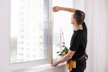 Photo for Master in gloves adjusting pvc windows with screwdriver closeup. Installation of plastic windows repair and maintenance concept. High quality photo - Royalty Free Image