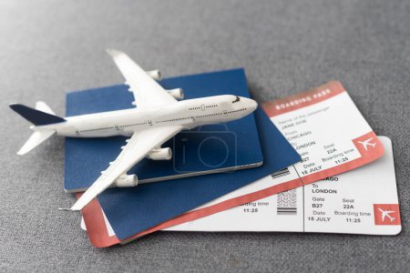 Foto de Passports, boarding passes and toy airplane on gray table. - Imagen libre de derechos