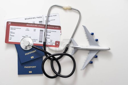 seguro de salud en concepto de viaje. atención médica en el extranjero. estetoscopio, avión de juguete y pasaportes.