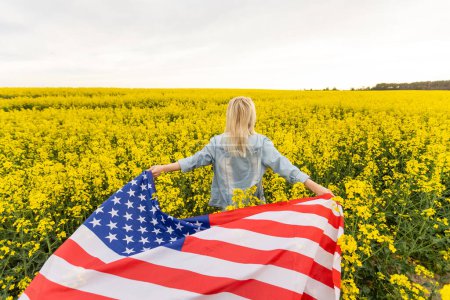Téléchargez les photos : Pays, patriotisme, fête de l'indépendance et concept des gens - heureuse jeune femme souriante avec drapeau national américain sur le terrain. - en image libre de droit