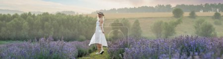 Photo for Beautiful young woman in wicker hat and white dress in a lavender field with. - Royalty Free Image