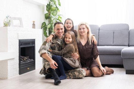 Soldier in camouflage and his family sitting at home.