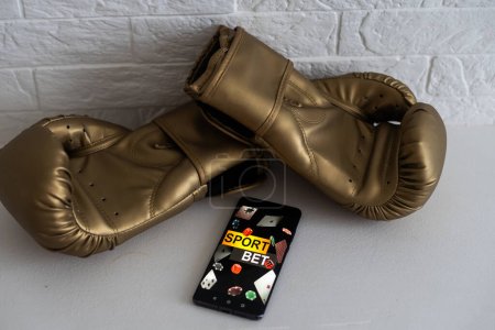 boxing gloves and smartphone with bets