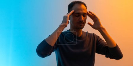 Photo for Portrait of bearded man in casual clothes having huge headache isolated on color background. - Royalty Free Image
