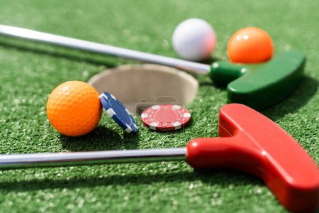 Photo for Casino chips and golf equipment on the green lawn - Royalty Free Image
