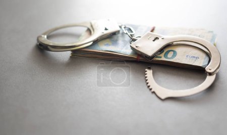 Foto de Handcuffs and Euro Money. economic fraud. - Imagen libre de derechos