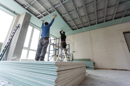 Téléchargez les photos : Travaux de plafond d'installation des travailleurs de la construction. Photo de haute qualité - en image libre de droit