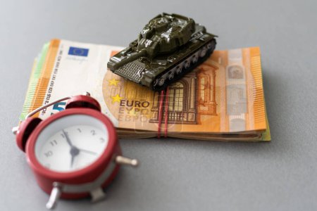 concepto de financiación de la guerra, tanque de juguete, euro, reloj.