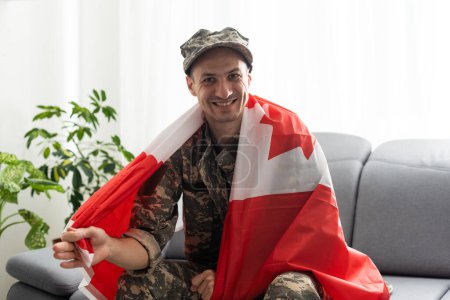 Photo for Man in military uniform holding canada national flag while - Royalty Free Image