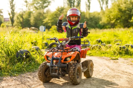 Photo for Little girl riding ATV quad bike in race track - Royalty Free Image