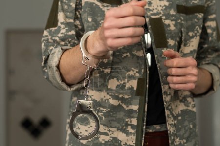 Photo for Handcuffed soldier in military army clothes. Close up of hands in handcuffs. - Royalty Free Image