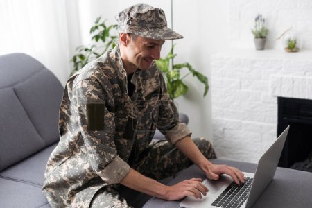 Foto de Recortado disparo de un soldado adulto medio buscando reflexivo mientras trabajaba en su computadora portátil. - Imagen libre de derechos