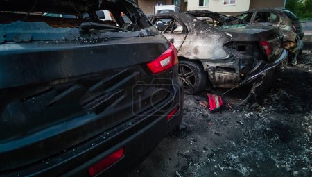 Kaputte und verbrannte Autos auf dem Parkplatz, Unfall oder vorsätzlicher Vandalismus. Verbranntes Auto. Folgen eines Autounfalls. Durch Brandstiftung beschädigt. Von russischen Truppen in der Ukraine beschossene Zivilfahrzeuge