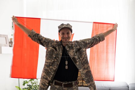 Foto de Vista parcial del hombre en uniforme militar sosteniendo la bandera nacional de Canadá - Imagen libre de derechos