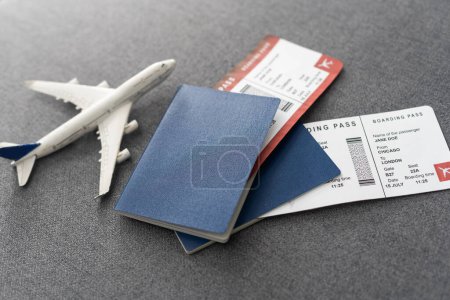 Photo for Toy airplane and passport with tickets on gray background, top view. - Royalty Free Image
