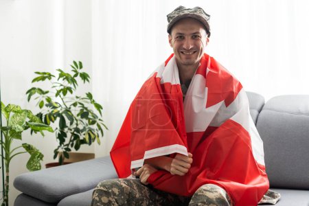 Foto de Vista parcial del hombre en uniforme militar sosteniendo la bandera nacional de Canadá - Imagen libre de derechos
