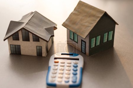 Concepto de bienes raíces - Casa modelo en miniatura con calculadora.