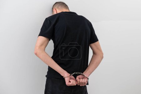 Photo for Mens hands closed in chrome handcuffs. - Royalty Free Image