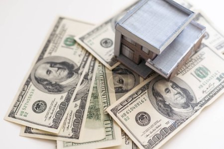 Photo for Paper house model on background of US dollars banknotes. Housing market, purchase or rental of real estate. - Royalty Free Image