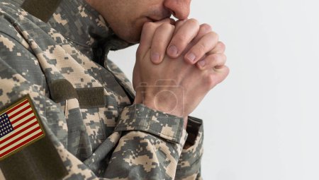 National American holidays. male praying soldier o with an American flag. Copy space. The concept of Veterans Day.