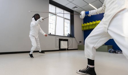 Photo for Portrait of kids and adults fencers with trainer engaged in fencing in training room. High quality photo - Royalty Free Image