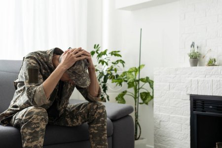 Photo for A man in a military uniform is sitting in a chair by the window. Concept: a soldier at a psychologists appointment, post-traumatic stress syndrome, mental disorder, the consequences of war. - Royalty Free Image