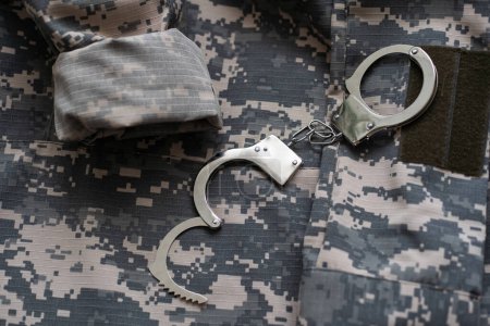 Photo for Military camouflage uniform, handcuffed on background - Royalty Free Image