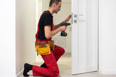 Photo for Young repairman checking new door lock. High quality photo - Royalty Free Image