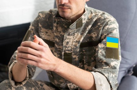 A Ukrainian military man holds the national flag in his hands as a symbol of strong. War in Ukraine