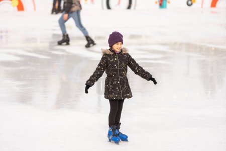 Téléchargez les photos : Teenage girl ice skating on rink outdoors. - en image libre de droit