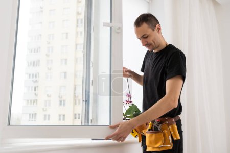 Trabajador de la construcción instalando ventana en casa. Foto de alta calidad