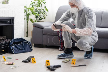 Photo for Criminological expert collecting evidence at the crime scene. High quality photo - Royalty Free Image