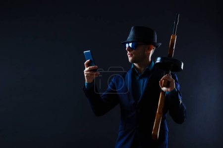 Téléchargez les photos : Mature man in sunglasses with gun. - en image libre de droit