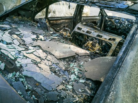 Téléchargez les photos : Une vue de face recadrée d'une voiture rouillée brûlée et abandonnée. - en image libre de droit