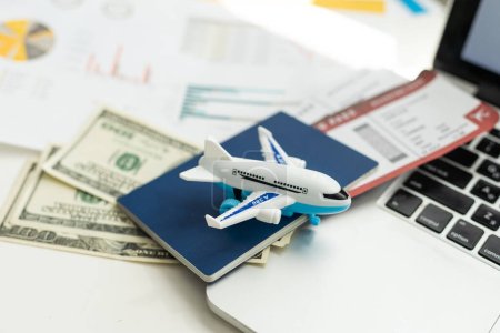 Billetes de avión, pasaportes, dinero y avión de juguete en la mesa. Foto de alta calidad