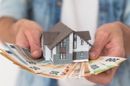 Photo for Property buyer holding euro banknotes and buying beautiful flat from real estate agencies on blurred background. High quality photo - Royalty Free Image