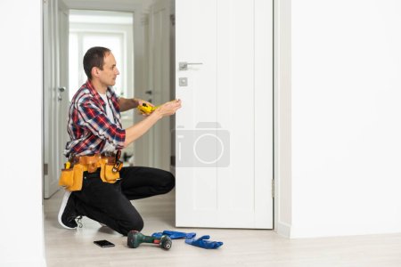 High Angle View Of Male Carpenter With Screwdriver Fixing Door Lock. High quality photo