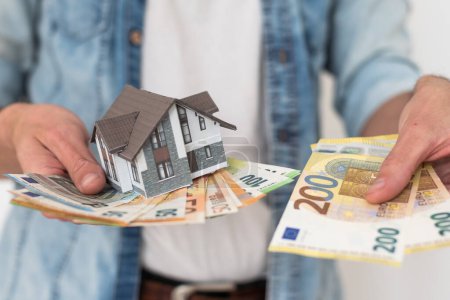 Photo for Property buyer holding euro banknotes and buying beautiful flat from real estate agencies on blurred background. High quality photo - Royalty Free Image
