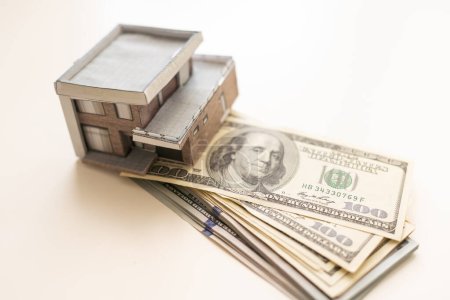 Photo for Paper house model on background of US dollars banknotes. Housing market, purchase or rental of real estate. - Royalty Free Image