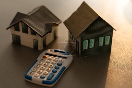 Concepto de bienes raíces - Casa modelo en miniatura con calculadora.