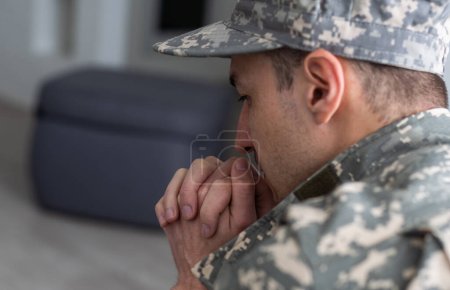 Foto de Un hombre con uniforme militar está sentado en una silla junto a la ventana. Concepto: un soldado en una cita de psicólogos, síndrome de estrés postraumático, trastorno mental, las consecuencias de la guerra. - Imagen libre de derechos