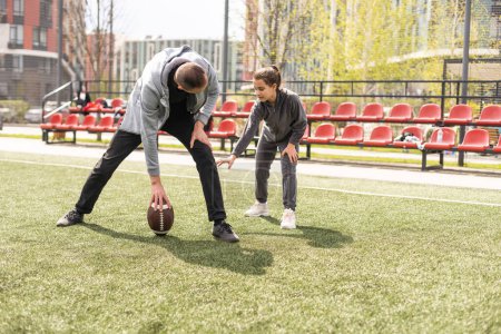 Photo for Family Playing American Football Together In Park - Royalty Free Image