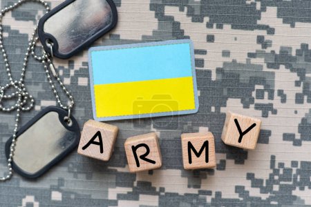 Military patch and bullets on pixel Ukrainian camouflage, closeup. High quality photo