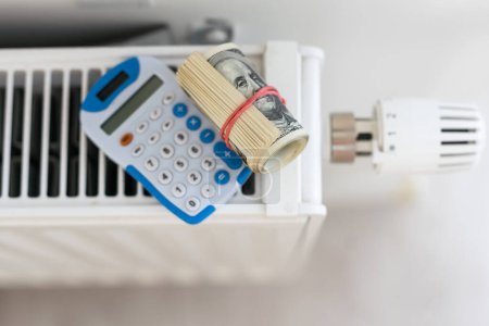 Téléchargez les photos : Thermostat de chauffage avec de l'argent, un dollar, concept coûteux de coûts de chauffage. Photo de haute qualité - en image libre de droit