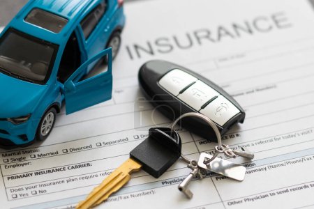 Ansicht des Antragsformulars für Autoversicherungen mit Autoschlüssel und Autospielzeug auf dem Schreibtisch.