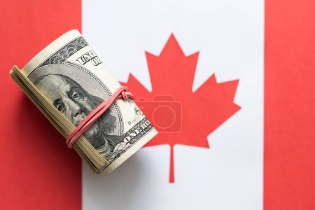 Dollars on flag of Canada, Canadian finance, subsidies, social support, GDP concept. High quality photo