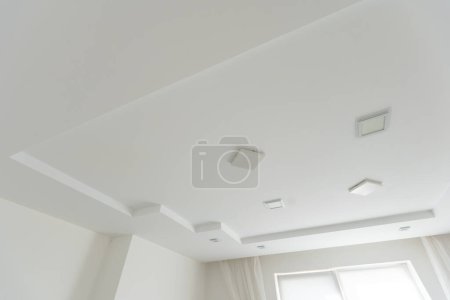 Stretched white matte ceiling in the room close-up. High quality photo