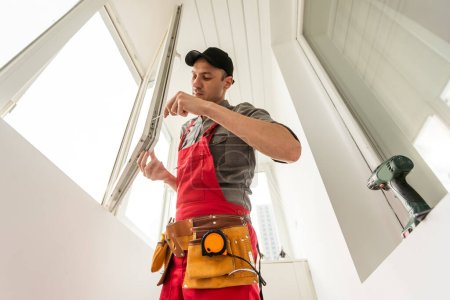 Foto de Trabajador constructor industrial masculino en la instalación de ventanas en el sitio de construcción de edificios. Foto de alta calidad - Imagen libre de derechos